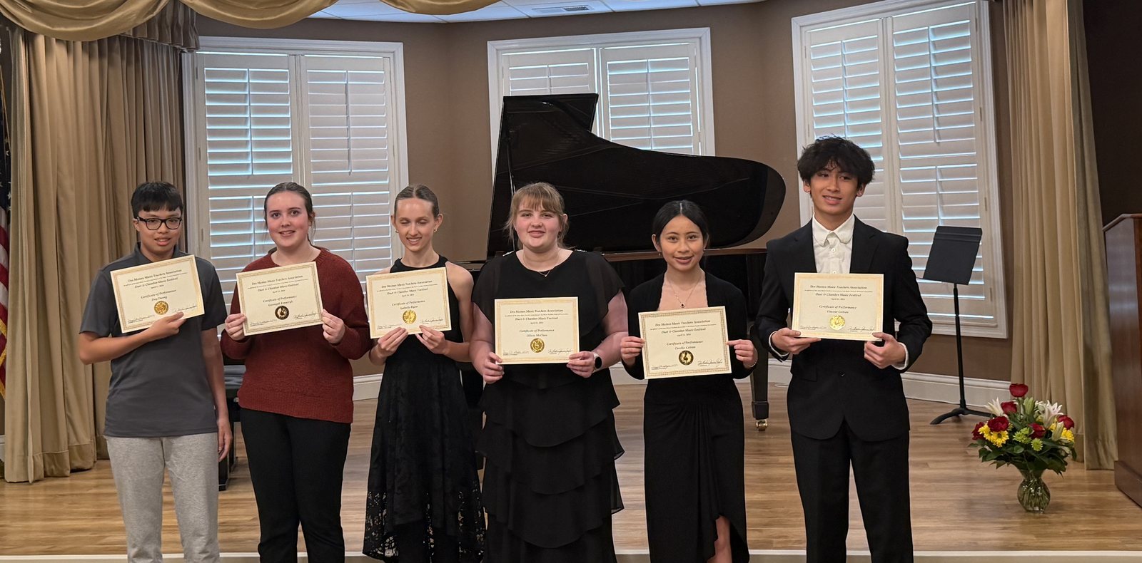 Six Caruth Piano Studio students on stage holding certificates of performance