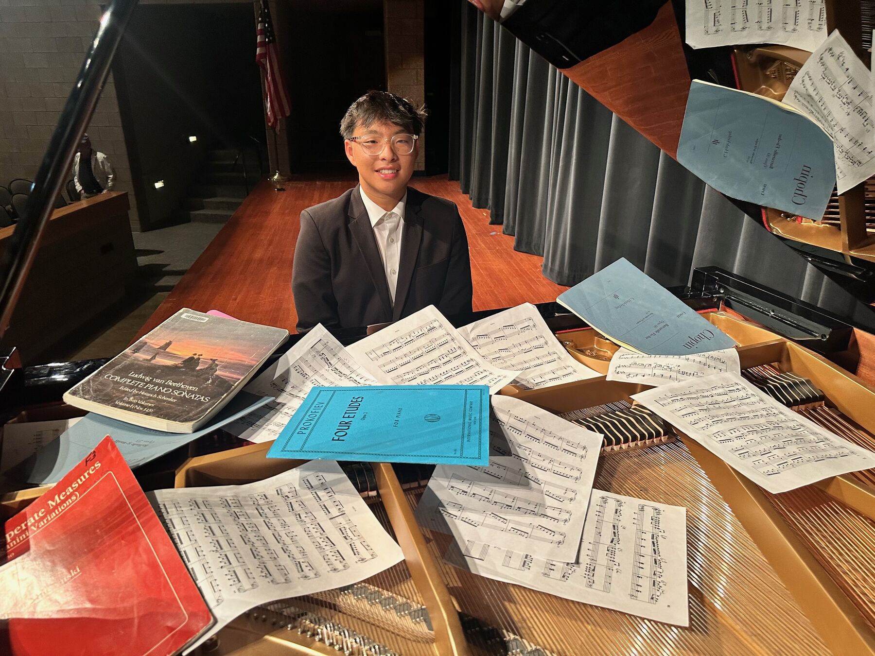 Sheet music and repertoire spread across the piano at Caruth Piano Studio