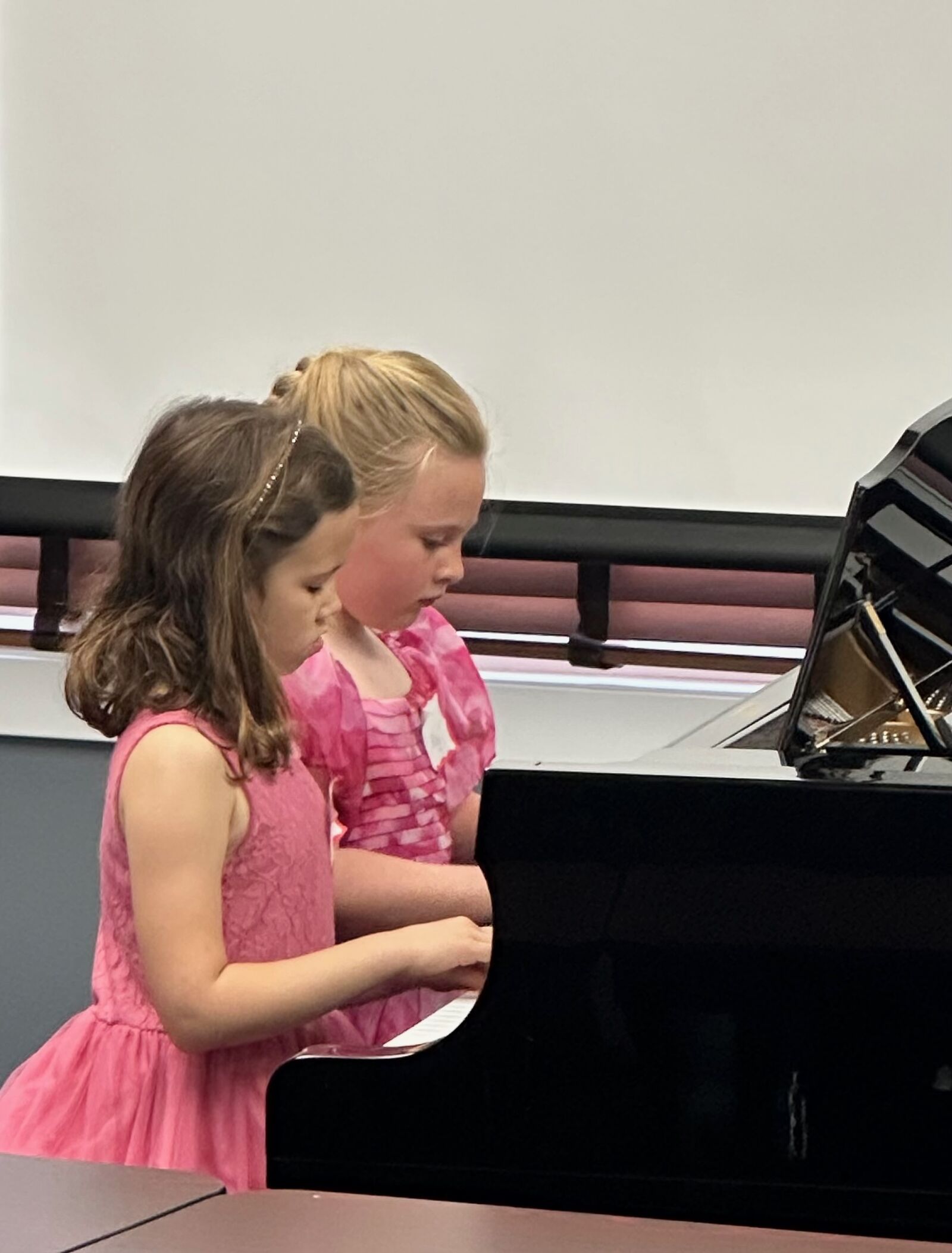 Two young Caruth Piano Studio beginners at the piano together